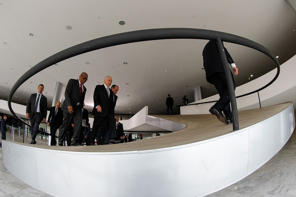Carvalho walking up curved steps with a group of political figures