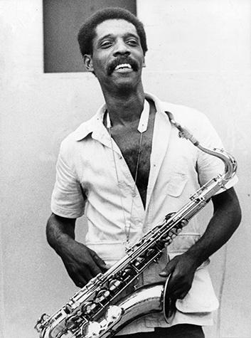 Walden smiling, holding alto saxophone