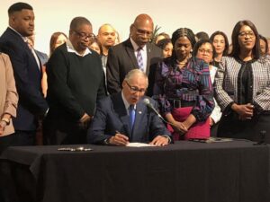 Washington Gov. Jay Inslee Signing Covenant Homeownership Bill into May 8, 2023. Jamila Taylor is Standing Besides the Governor (Quintard Taylor Collection)