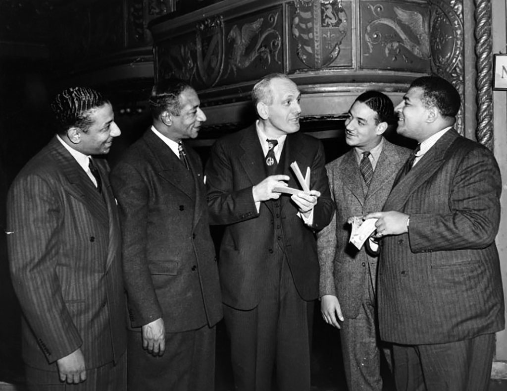https://www.blackpast.org/wp-content/uploads/prodimages/files/blackpast_images/Mills_Brothers_with_Gabriel_Heatter_center_New_York_1935_1945.jpg
