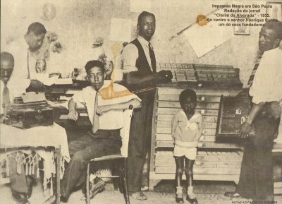 Workers and a child sitting and standing around a table and paper drawers